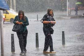 Imagen referencia de dos mujeres caminando bajo la lluvia en Bogotá