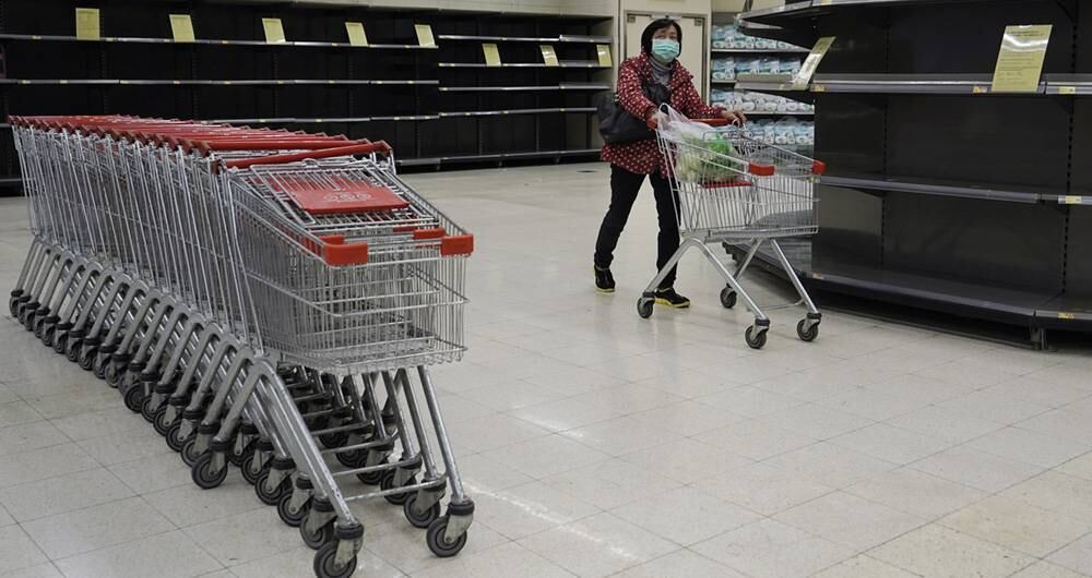En los últimos días, los habitantes de Hong Kong han comprando grandes cantidades de productos porque temen que las restricciones fronterizas, aplicadas para controlar el brote del virus, puedan afectar los flujos de suministro. En la foto, una mujer hace compras en un supermercado, el 7 de febrero de 2020. Foto: Kin Cheung/ AP. 